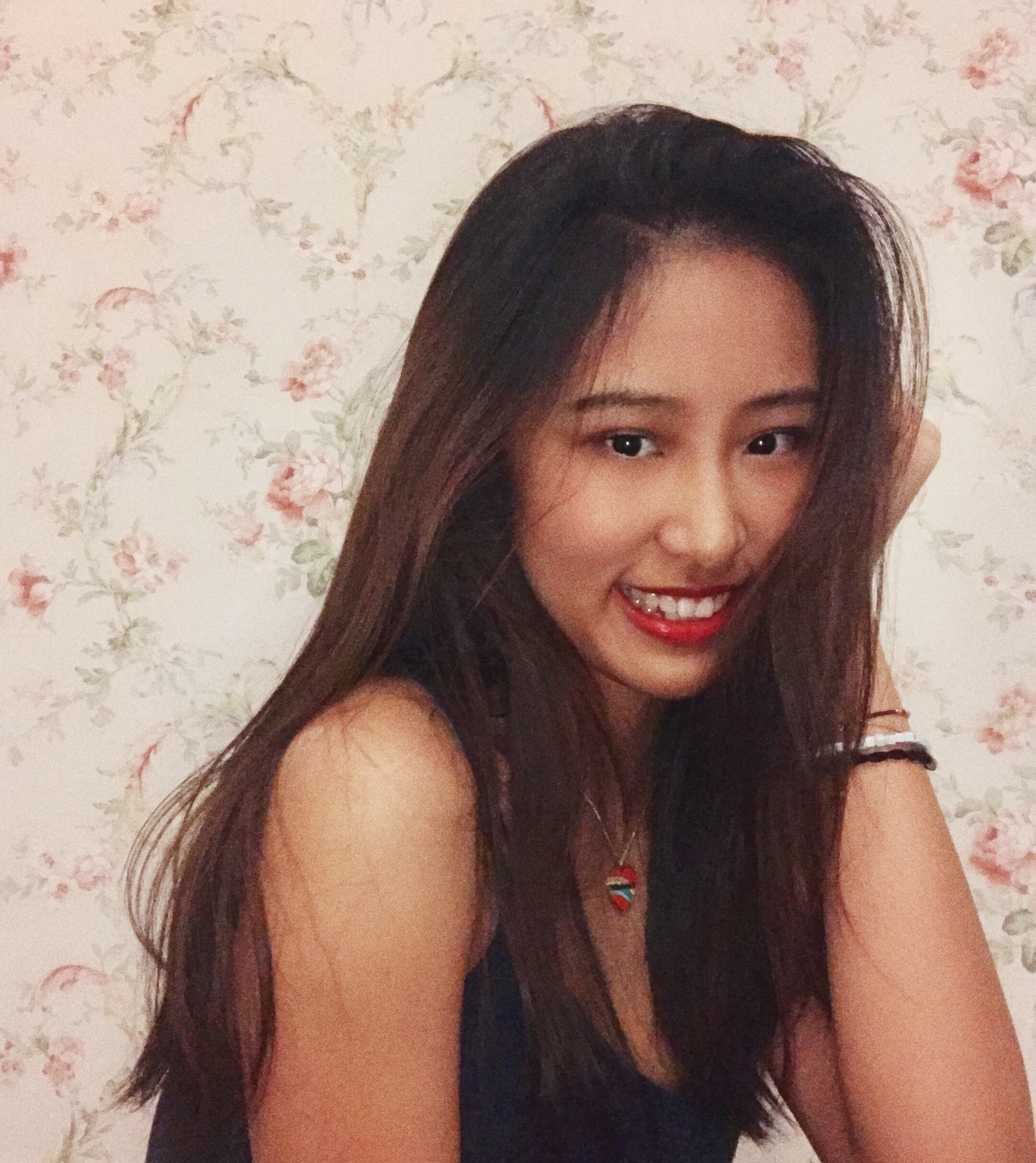 Aria Yang 2019-2020 Teen Advisors (headshot, eyes looking down angle) with her smiley face facing to the camera, and her left hand holding aginst her head