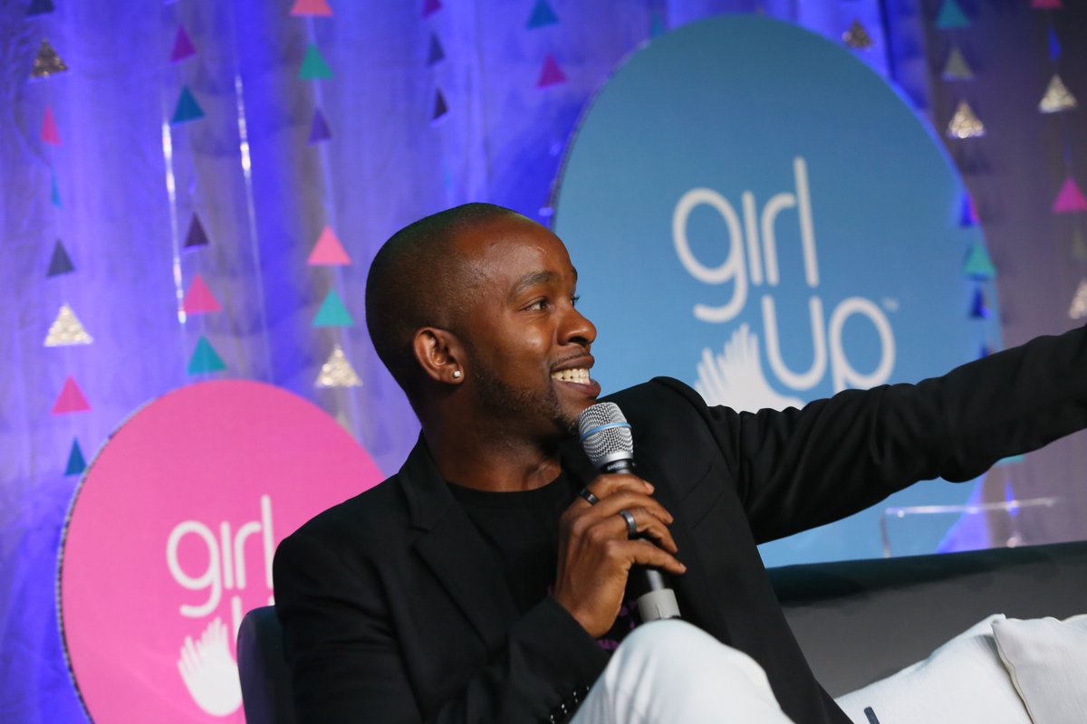 Wade Davis holding the mic , and only showing his side face with smile and left hand pointing at the crowd