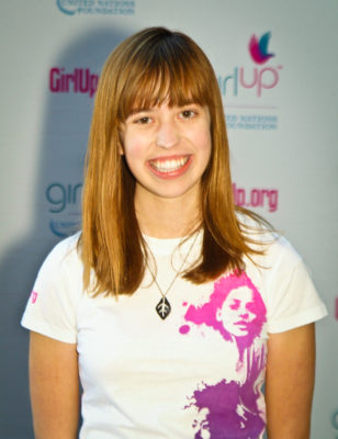 Emily Harwell_2011-2012 Class Teen Advisors (close angle headshot) a teen girl wearing her girl up white shirt with her smiley face facing the camera, and background is girlup.org board