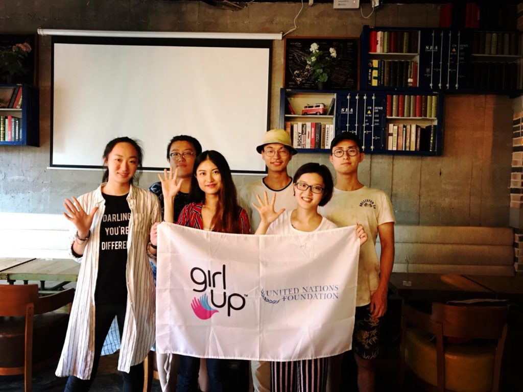 girls in shanghai with 3 girls in the front and 3 men in the back holding the girl up flag