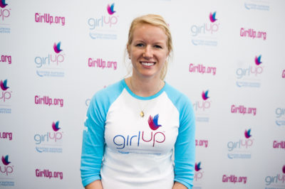 Jenna Bailey,The founding class of Teen Advisors (close angle, but not clear picture headshot ) a teen girl wearing her girl up blue long shirt with her smile face facing the camera her girl up blue long shirt, and background is girlup.org board