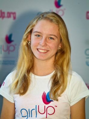 Jillian Murray_Hometown: Chevy Chase, MD_2011-2012 Class The second class of Teen Advisors (close angle headshot) a teen girl wearing her girl up white shirt with her smiley face facing the camera, and background is girlup.org board