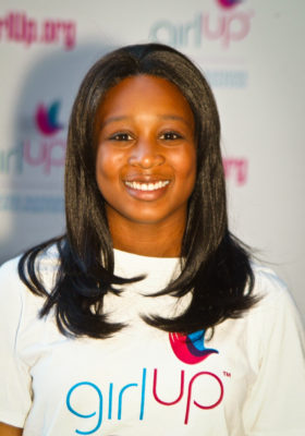 Joi Collete Stevens_Hometown: San Antonio, TX_2011-2012 Class The second class of Teen Advisors (close angle headshot) a teen girl wearing her girl up white shirt with her smiley face facing the camera, and background is girlup.org board