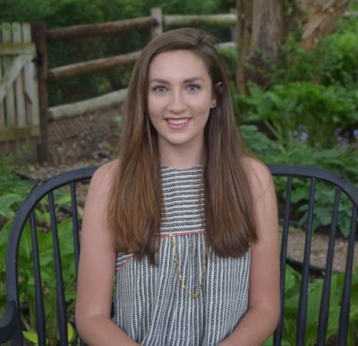 Meg Schwartz_2016-2017 Teen Advisors (close headshot) with her smiley face facing the camera, with background greenery grey