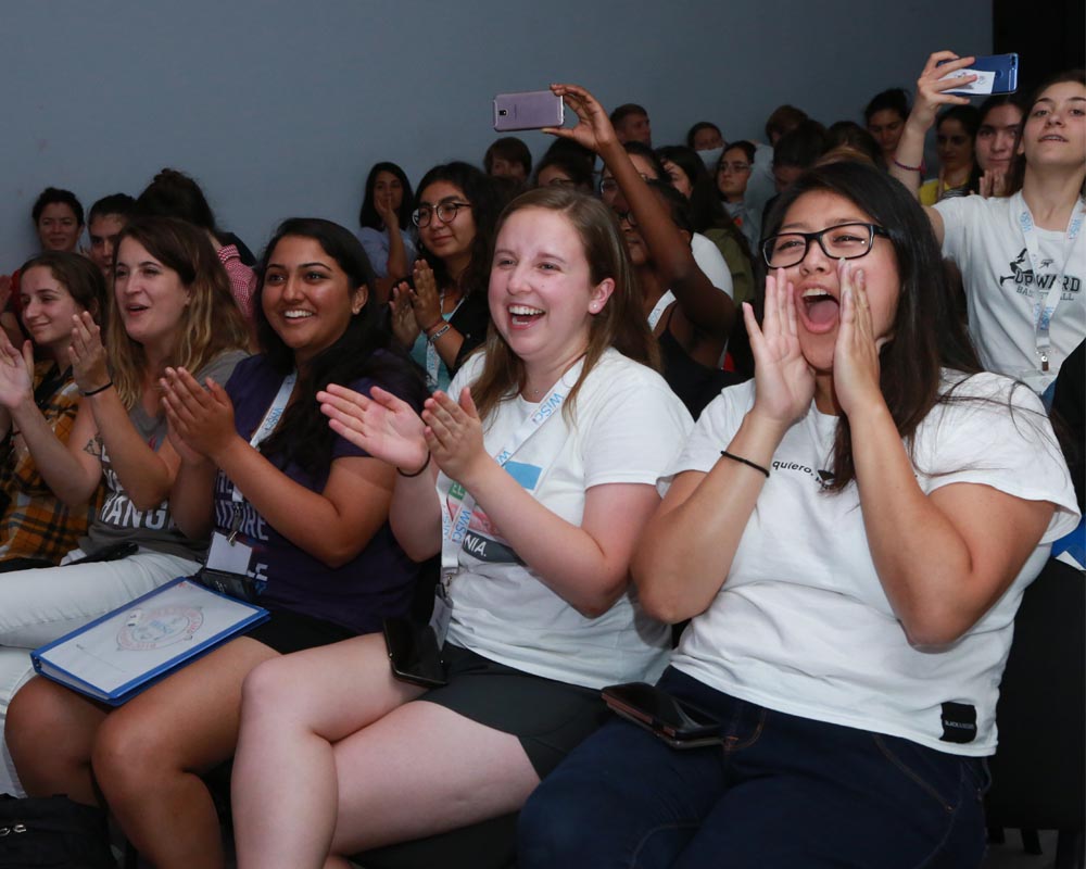 4 Girl Up staffs clapping and laughing and cheering in the crowd