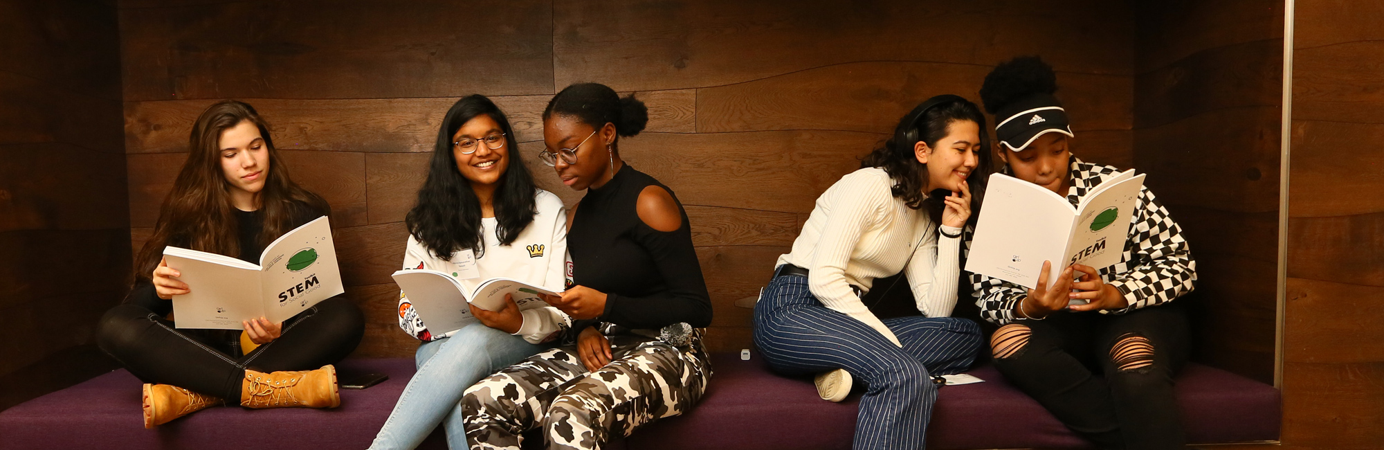 Group of 5 Girls holding a STEM toolkit book