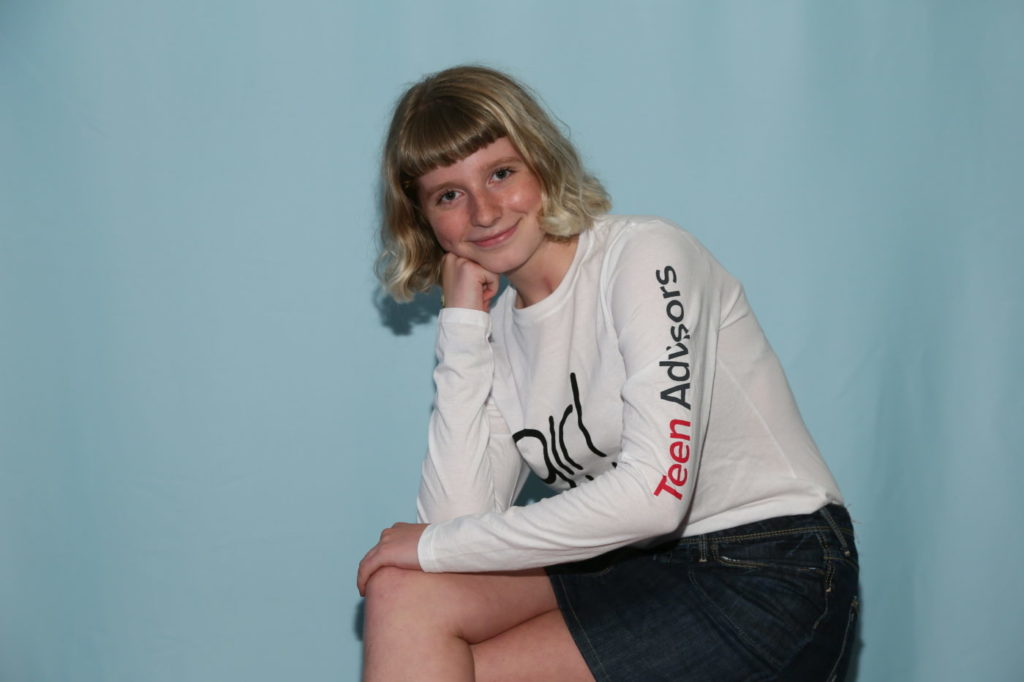 a teen advisor sitting cross her leg and holding her hand up with her right hand