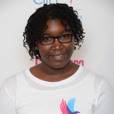 Thandiwe Diego_ 2014-2015 Teen Advisors (close angle headshot ) a teen girl wearing her girl up white shirt with her smiley face facing the camera, and background is girlup.org board