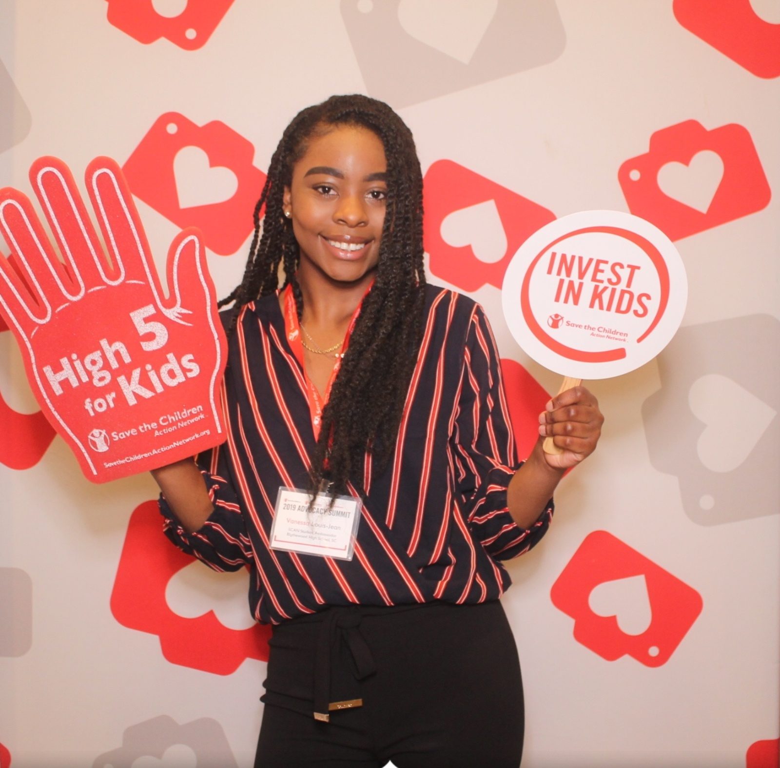 Vanessa Louis-Jean2019-2020 Teen Advisors (headbody shot) with her smiley face facing to the camera , and holding sign "high 5 for kids" and "invest in kids"