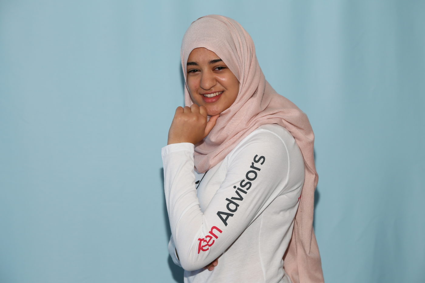 Leena teen advisor (girl up shirt)pose for the picture with her Hijab on (blue background)