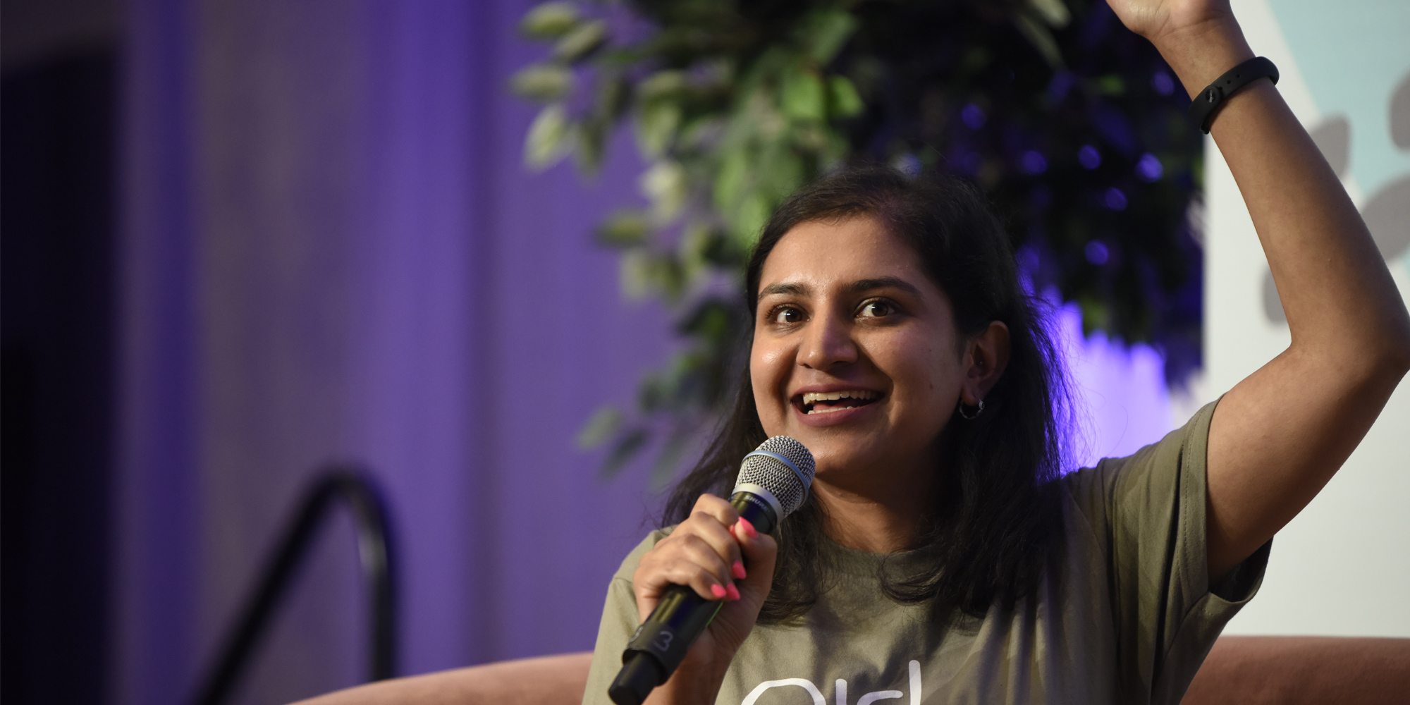 a girl holding a mic and arsing her left hand up