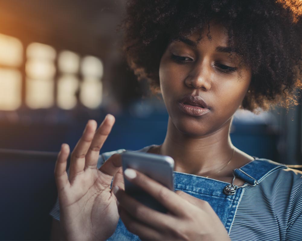 a girl who is looking down and using her finger to scrolling the phone