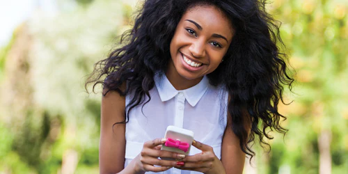 a girl with smile and looking straight and holding her iPhone