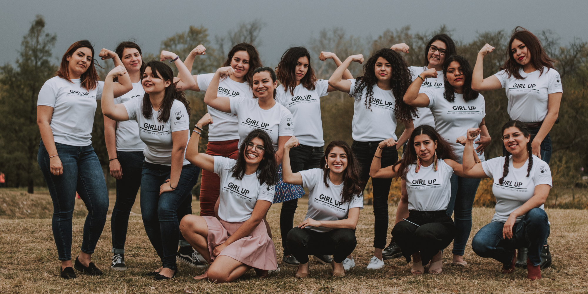 A group of Girl Up leaders posing with their arms flexed
